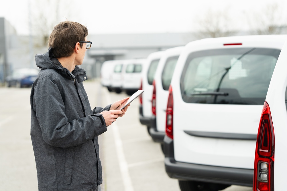 Fleet manager reviewing light commercial vehicle condition in a van park