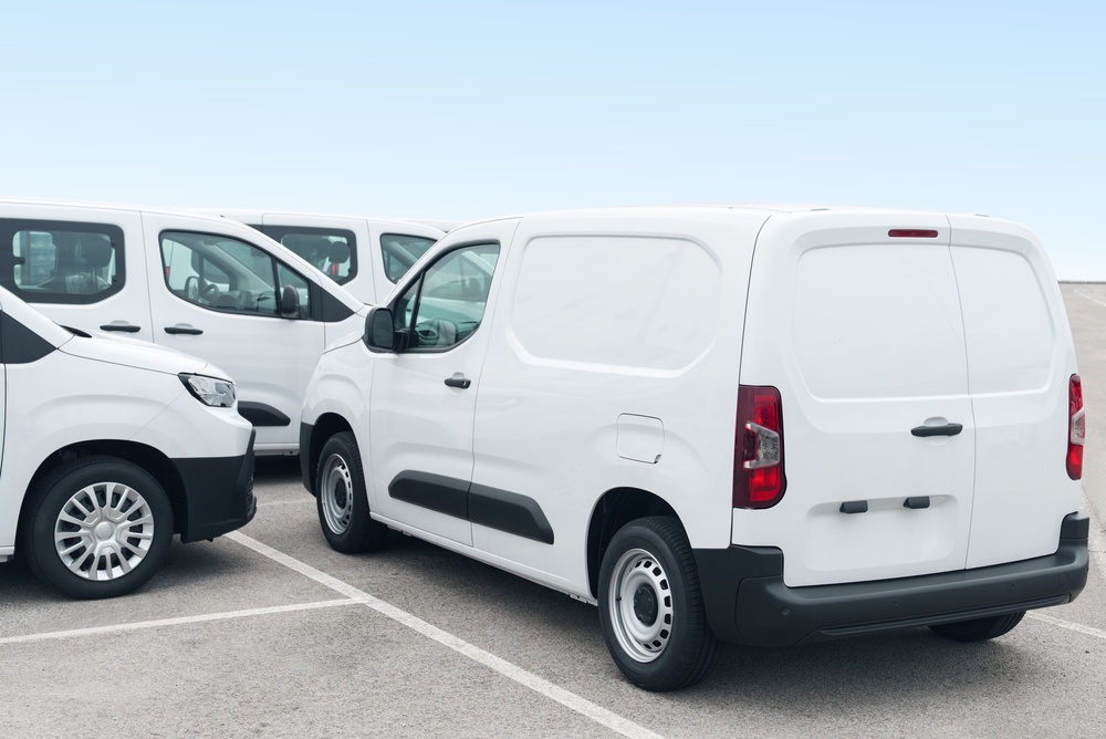 Fleet of white commercial vans parked in a secure lot